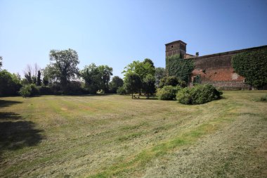 İtalya kırsalında güneşli bir günde bir bahçeden görülen bir şatonun köşesi.