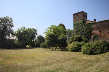 İtalya kırsalında güneşli bir günde bir bahçeden görülen bir şatonun köşesi.