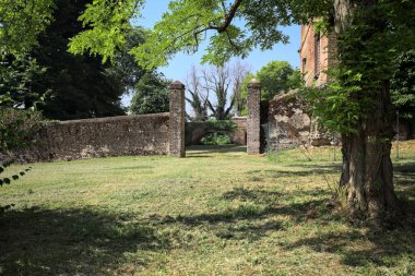 İtalya kırsalında güneşli bir günde bir bahçeden görülen bir şatonun köşesi.