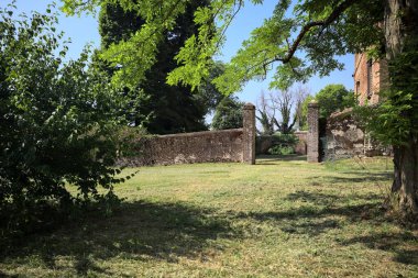 İtalya kırsalında güneşli bir günde bir bahçeden görülen bir şatonun köşesi.