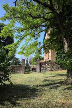 İtalya kırsalında güneşli bir günde bir bahçeden görülen bir şatonun köşesi.