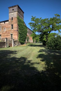 İtalya kırsalında güneşli bir günde bir bahçeden görülen bir şatonun köşesi.