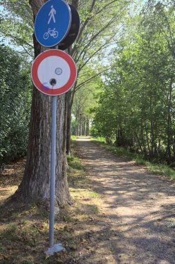 İtalya kırsalında güneşli bir günde, her iki tarafında gölgeler olan ağaçlarla çevrili patika.
