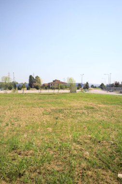 Güneşli bir günde, İtalya 'nın kırsal kesiminde, otoparkı ve terk edilmiş bir kır evi olan boş bir arazide.