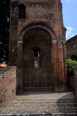 Güneşli bir günde, bir İtalyan kasabasında, bir parkın ortasında demir bir kapı tarafından kapatılmış bir çan kulesinin kalıntılarındaki üs.