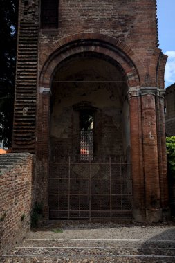 Güneşli bir günde, bir İtalyan kasabasında, bir parkın ortasında demir bir kapı tarafından kapatılmış bir çan kulesinin kalıntılarındaki üs.