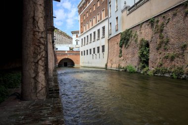 Bir İtalyan kasabasında yüksek binaların arasından geçen su akıntısı