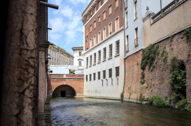 Bir İtalyan kasabasında yüksek binaların arasından geçen su akıntısı