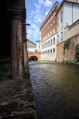 Bir İtalyan kasabasında yüksek binaların arasından geçen su akıntısı