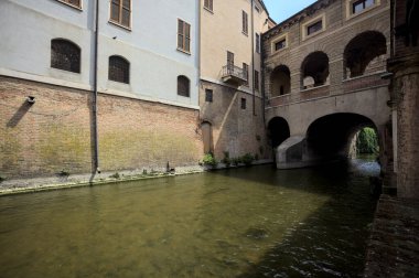 Bir İtalyan kasabasında dar bir su akıntısı üzerinde kemerli tuğla köprü