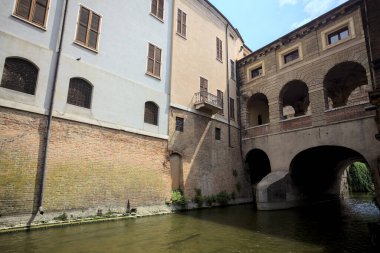 Bir İtalyan kasabasında dar bir su akıntısı üzerinde kemerli tuğla köprü