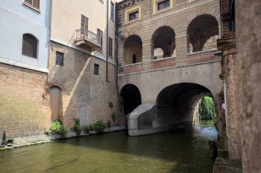 Bir İtalyan kasabasında dar bir su akıntısı üzerinde kemerli tuğla köprü