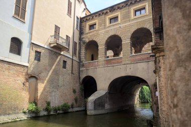 Bir İtalyan kasabasında dar bir su akıntısı üzerinde kemerli tuğla köprü