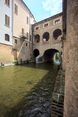 Bir İtalyan kasabasında dar bir su akıntısı üzerinde kemerli tuğla köprü