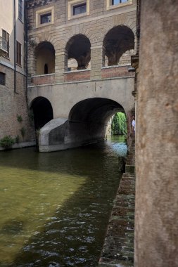 Bir İtalyan kasabasında dar bir su akıntısı üzerinde kemerli tuğla köprü
