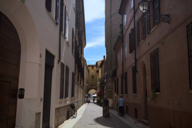 Bir İtalyan kasabasında dar bir sokak, yarı gölgede kemerli bir yol.