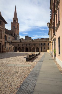 Mantova, İtalya - 27 Temmuz 2025 - Güneşli bir günde San Andrea Bazilikası 'nın bir tarafında çan kulesi ve bitişik binası ile kaldırımlı meydan