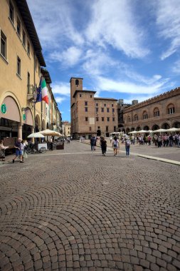 Mantova, İtalya - 27 Temmuz 2025 - Güneşli bir günde İtalya 'da bir meydanın kenarında saat kulesi olan bir saray