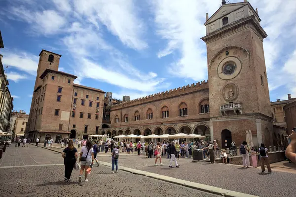 Mantova, İtalya - 27 Temmuz 2025 - Güneşli bir günde İtalya 'da bir meydanın kenarında saat kulesi olan bir saray