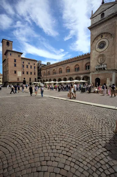 Mantova, İtalya - 27 Temmuz 2025 - Güneşli bir günde İtalya 'da bir meydanın kenarında saat kulesi olan bir saray