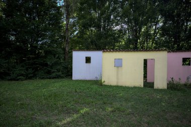 Parktaki bir grup ağacın arkasındaki ev cephesi şeklinde sanatsal kurulum