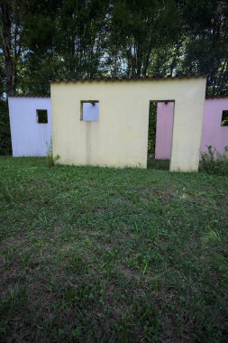 Parktaki bir grup ağacın arkasındaki ev cephesi şeklinde sanatsal kurulum