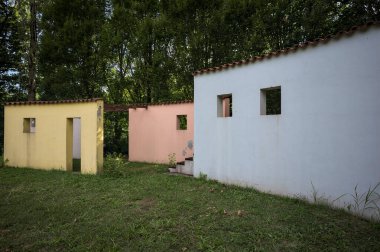 Parktaki bir grup ağacın arkasındaki ev cephesi şeklinde sanatsal kurulum