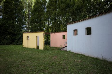 Parktaki bir grup ağacın arkasındaki ev cephesi şeklinde sanatsal kurulum