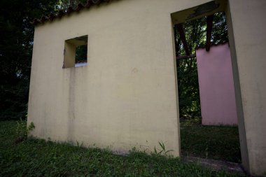 Parktaki bir grup ağacın arkasındaki ev cephesi şeklinde sanatsal kurulum