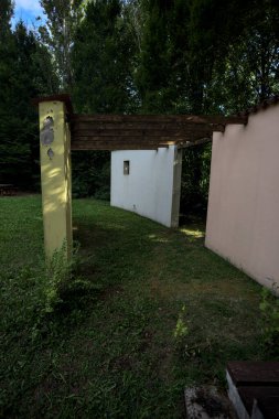 Parktaki bir grup ağacın arkasındaki ev cephesi şeklinde sanatsal kurulum