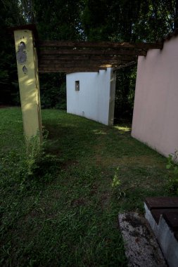 Parktaki bir grup ağacın arkasındaki ev cephesi şeklinde sanatsal kurulum