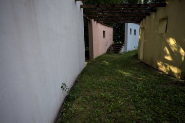 Parktaki bir grup ağacın arkasındaki ev cephesi şeklinde sanatsal kurulum