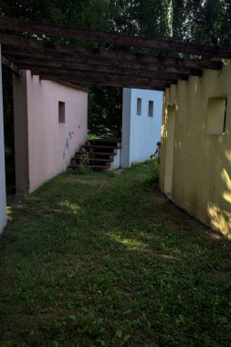 Parktaki bir grup ağacın arkasındaki ev cephesi şeklinde sanatsal kurulum