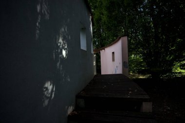 Parktaki bir grup ağacın arkasındaki ev cephesi şeklinde sanatsal kurulum