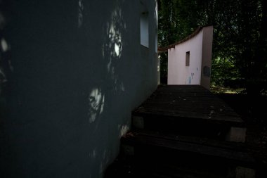 Parktaki bir grup ağacın arkasındaki ev cephesi şeklinde sanatsal kurulum