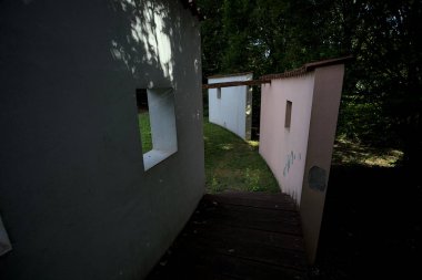 Parktaki bir grup ağacın arkasındaki ev cephesi şeklinde sanatsal kurulum