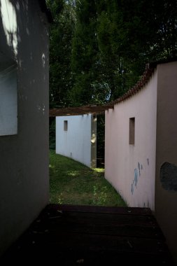 Parktaki bir grup ağacın arkasındaki ev cephesi şeklinde sanatsal kurulum