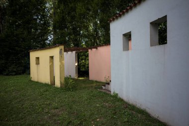 Parktaki bir grup ağacın arkasındaki ev cephesi şeklinde sanatsal kurulum