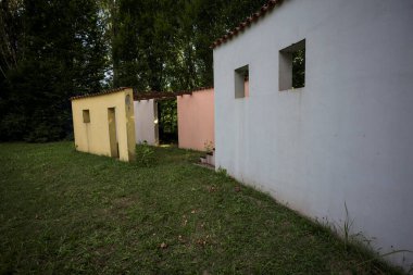 Parktaki bir grup ağacın arkasındaki ev cephesi şeklinde sanatsal kurulum