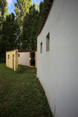 Parktaki bir grup ağacın arkasındaki ev cephesi şeklinde sanatsal kurulum