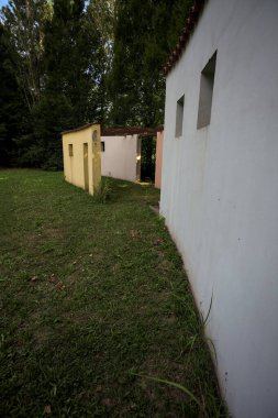 Parktaki bir grup ağacın arkasındaki ev cephesi şeklinde sanatsal kurulum