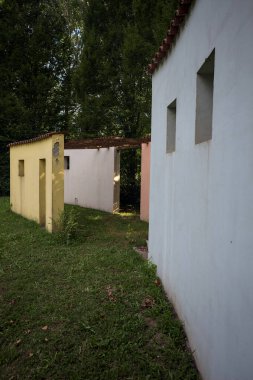 Parktaki bir grup ağacın arkasındaki ev cephesi şeklinde sanatsal kurulum