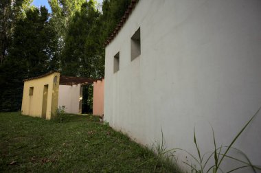 Parktaki bir grup ağacın arkasındaki ev cephesi şeklinde sanatsal kurulum