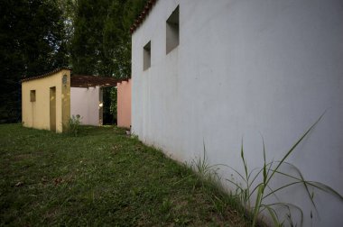 Parktaki bir grup ağacın arkasındaki ev cephesi şeklinde sanatsal kurulum