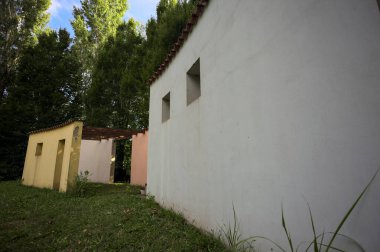 Parktaki bir grup ağacın arkasındaki ev cephesi şeklinde sanatsal kurulum