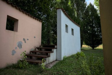 Parktaki bir grup ağacın arkasındaki ev cephesi şeklinde sanatsal kurulum