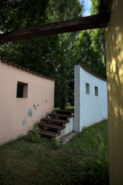 Parktaki bir grup ağacın arkasındaki ev cephesi şeklinde sanatsal kurulum