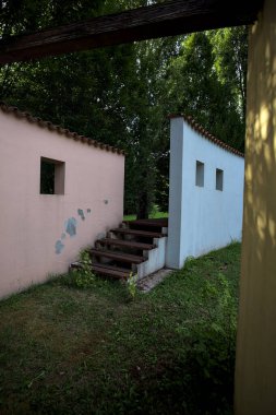 Parktaki bir grup ağacın arkasındaki ev cephesi şeklinde sanatsal kurulum