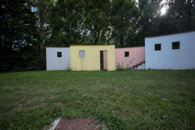 Parktaki bir grup ağacın arkasındaki ev cephesi şeklinde sanatsal kurulum