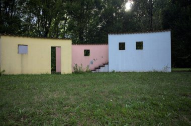 Parktaki bir grup ağacın arkasındaki ev cephesi şeklinde sanatsal kurulum